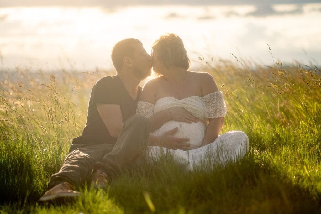 Un couple avec une femme enceinte s'embrassant dans le couché de soleil. Peyrins
