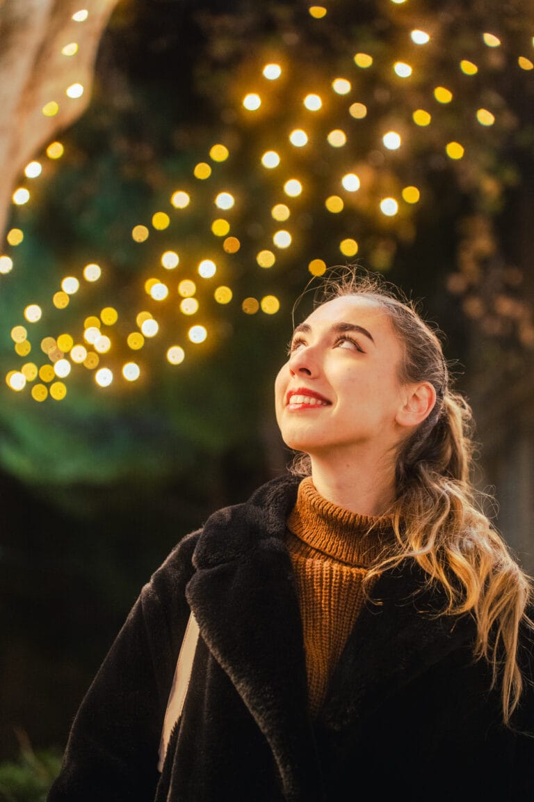 Une femme regardant des décorations de noël en souriant