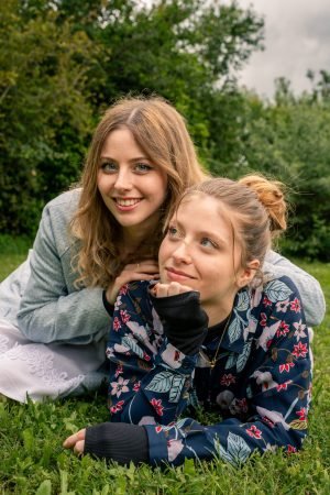 Deux soeurs souriante allongées dans l'herbe en souriant